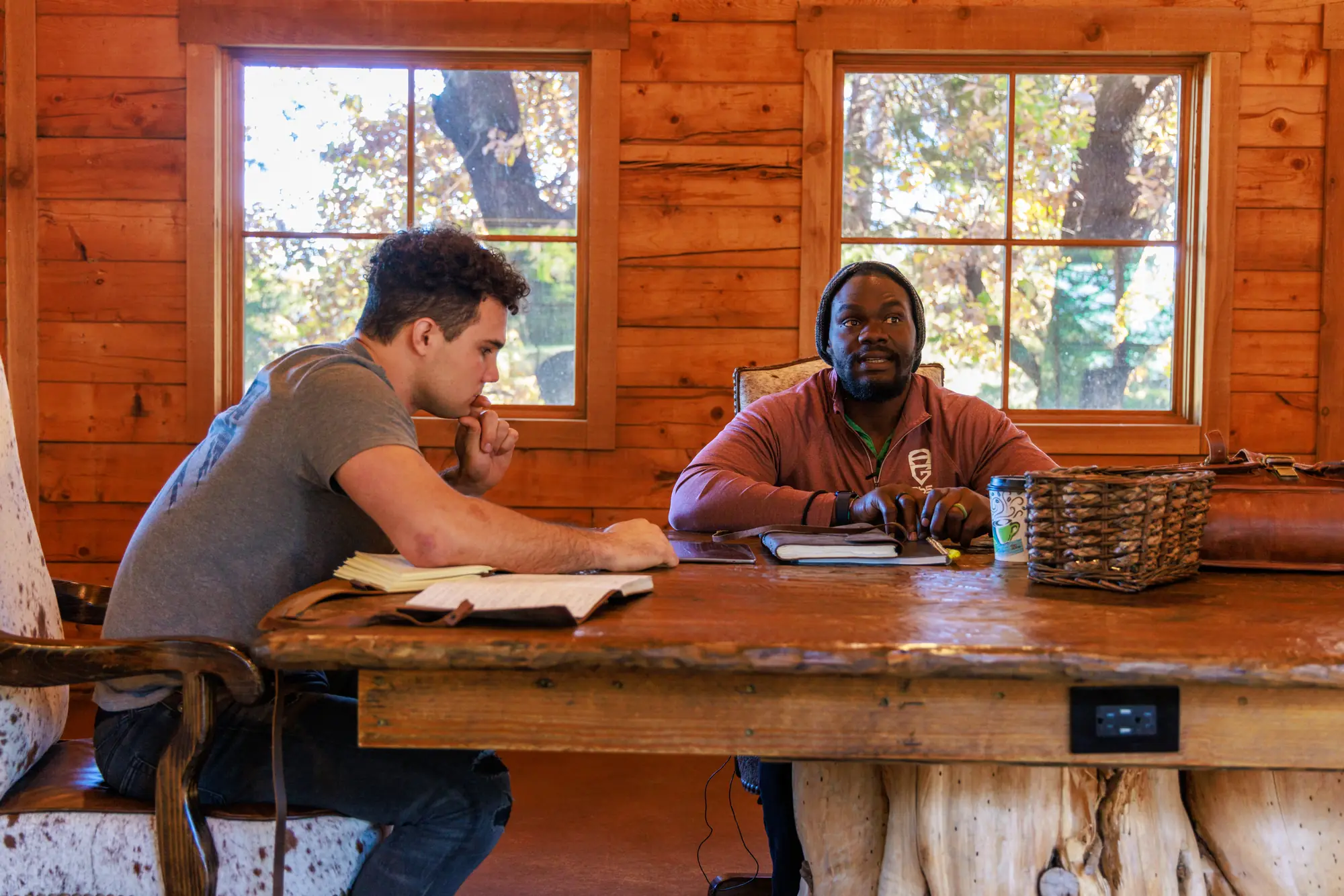 Holden Hill and Tommie Harris at work on Tommie's book at a long wooden table